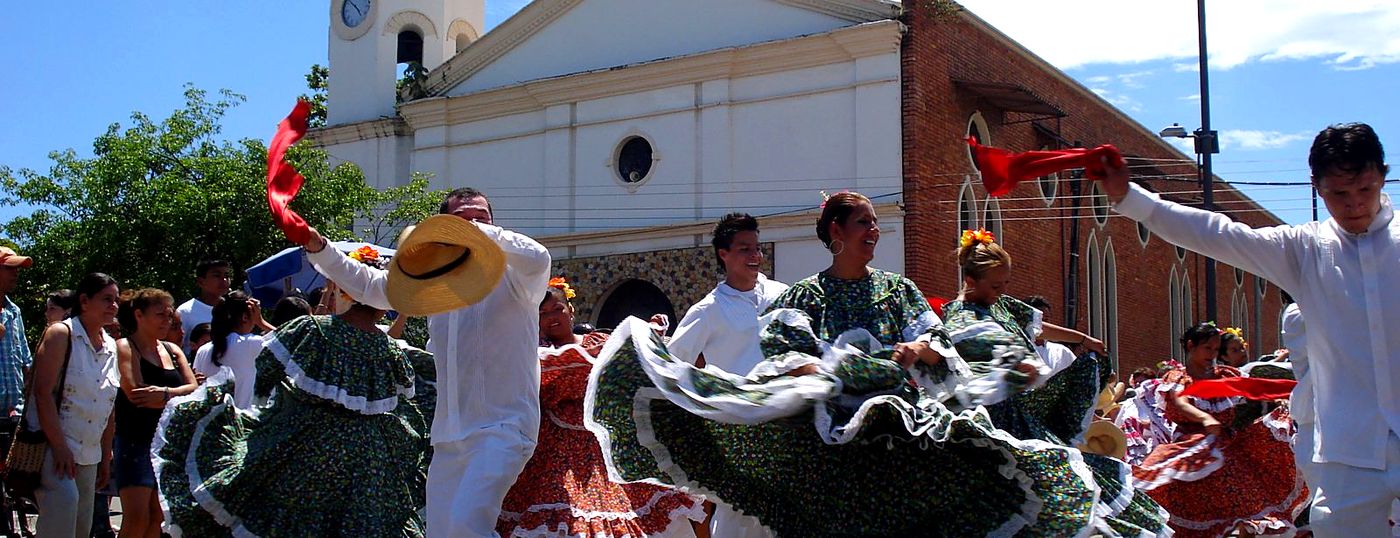 Parejas bailando danza folcl&oacute;rica con trajes t&iacute;picos frente a la iglesia de Melgar